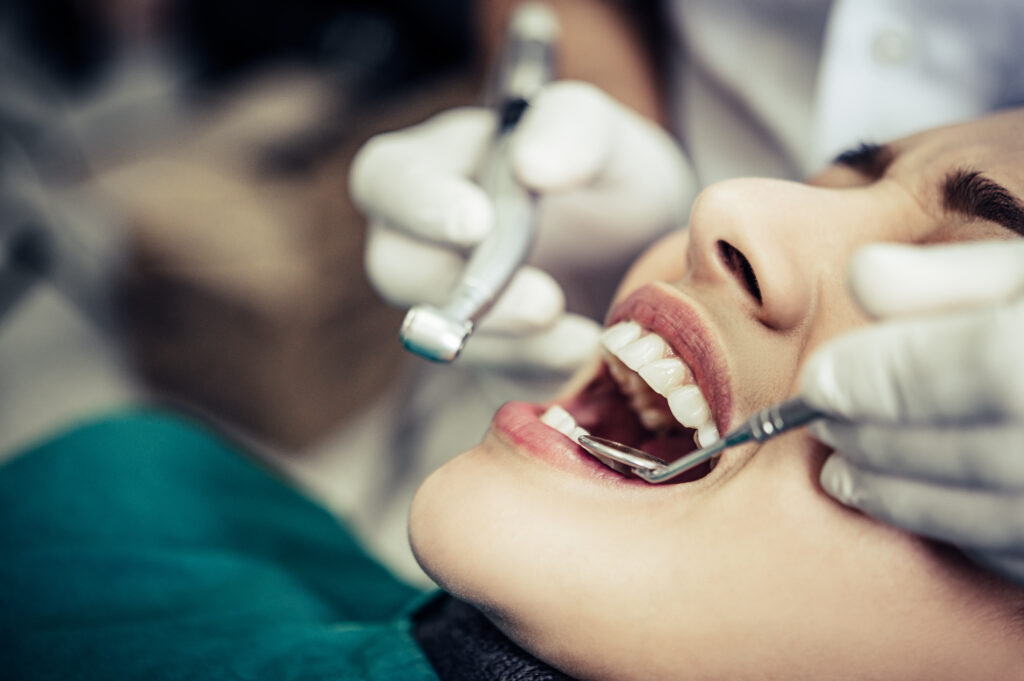 Dentist performing a dental checkup using modern equipment at a clinic in Doha.